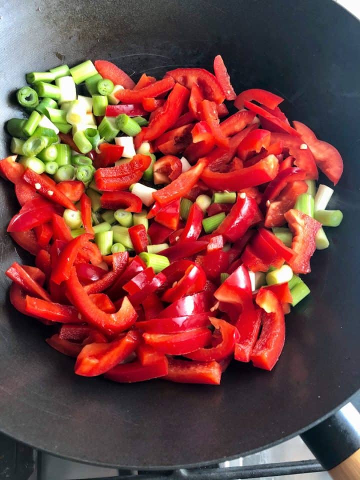 red peppers and spring onions frying in wok