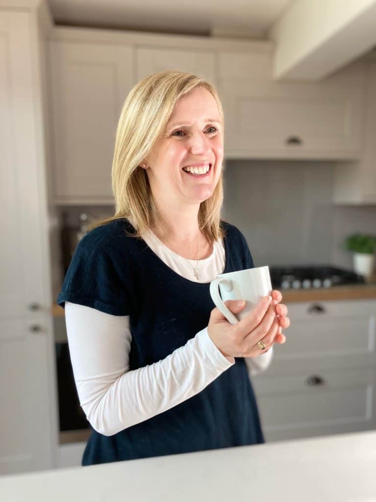 Claire Carter Profile standing in kitchen holding mug