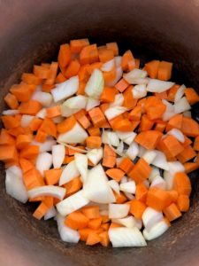 diced carrots and onions in pan