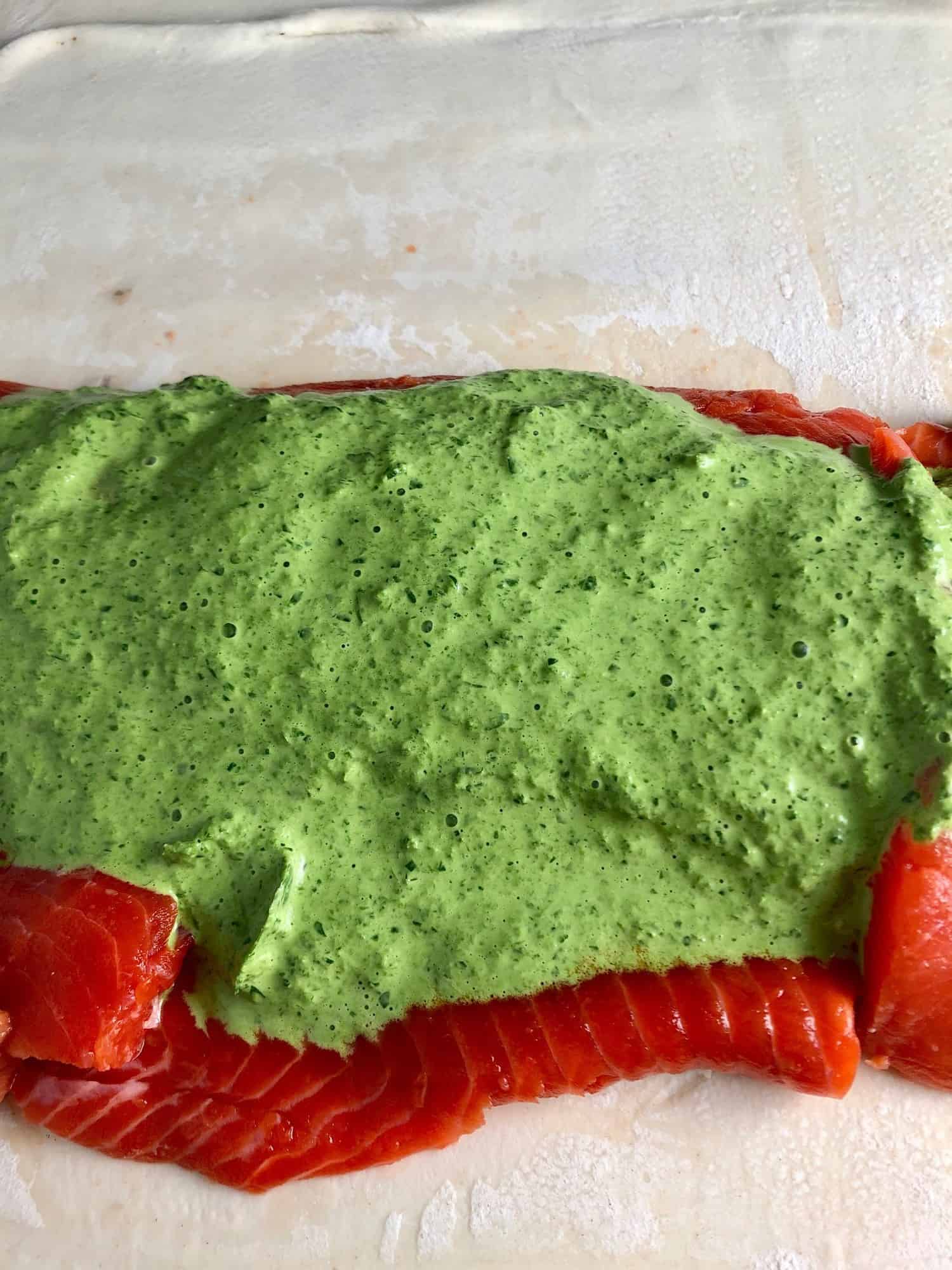 raw salmon covered cream cheese spianch sauce on puff pastry