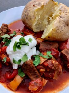 hungarian beef goulash with jacket potato and soured cream