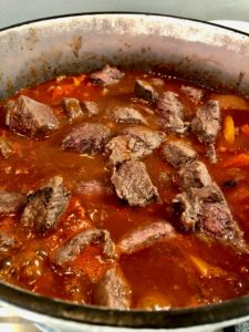 hungarian beef goulash simmering in pan