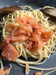smoked salmon added to spaghetti in frying pan
