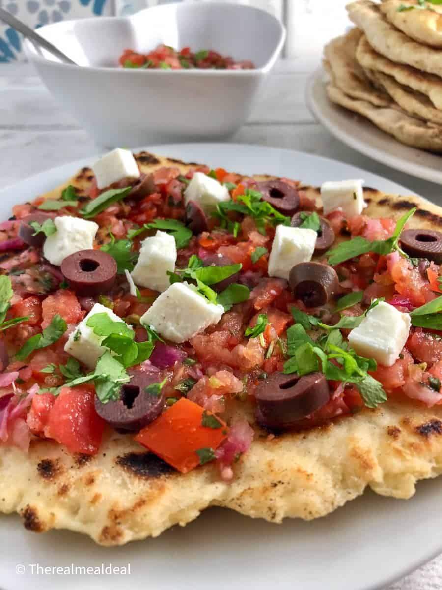 flatbread topped with salsa black olives feta cheese and parsley