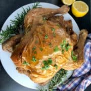 whole roasted chicken with rosemary and lemon halves