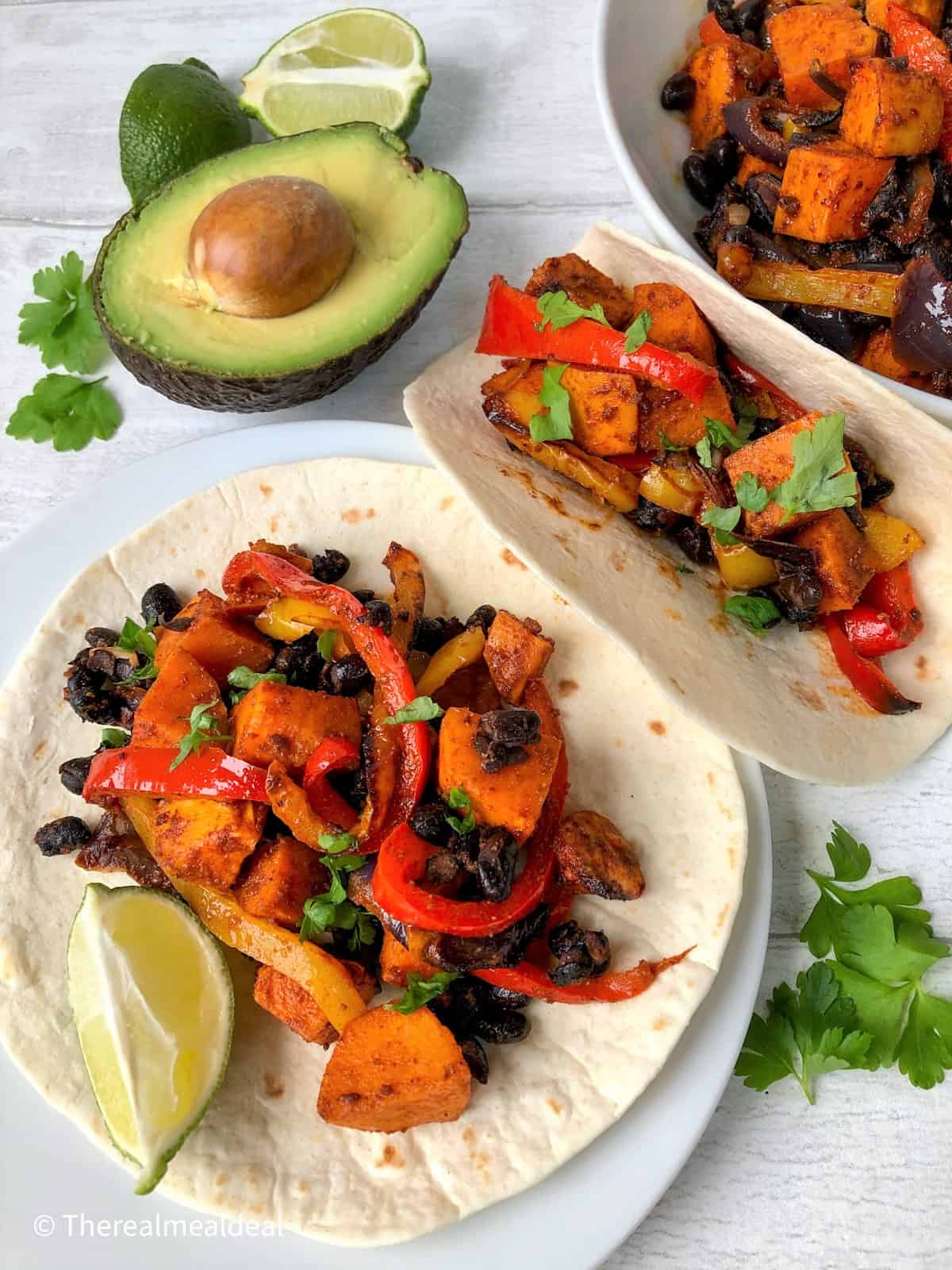 roasted vegetables on open tortillas served with avocado and slice lime