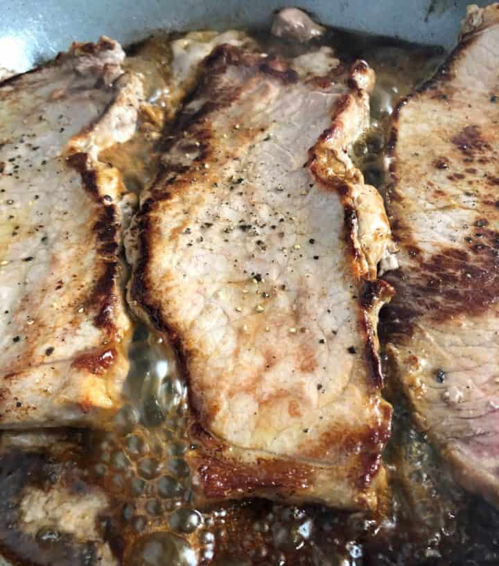 rose veal escalopes frying in pan