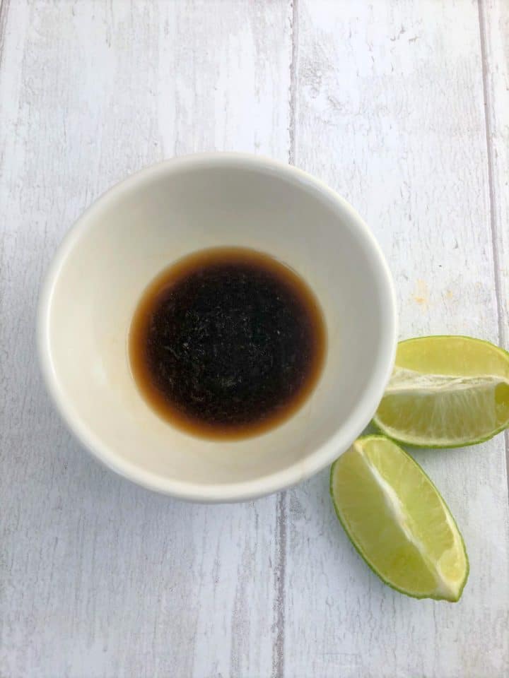 soy sauce lime juice and water mixed together in bowl next to lime wedges