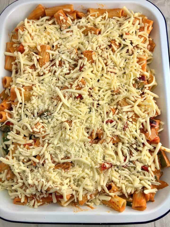 pasta bake in oven proof dish topped with grated mozarella cheese