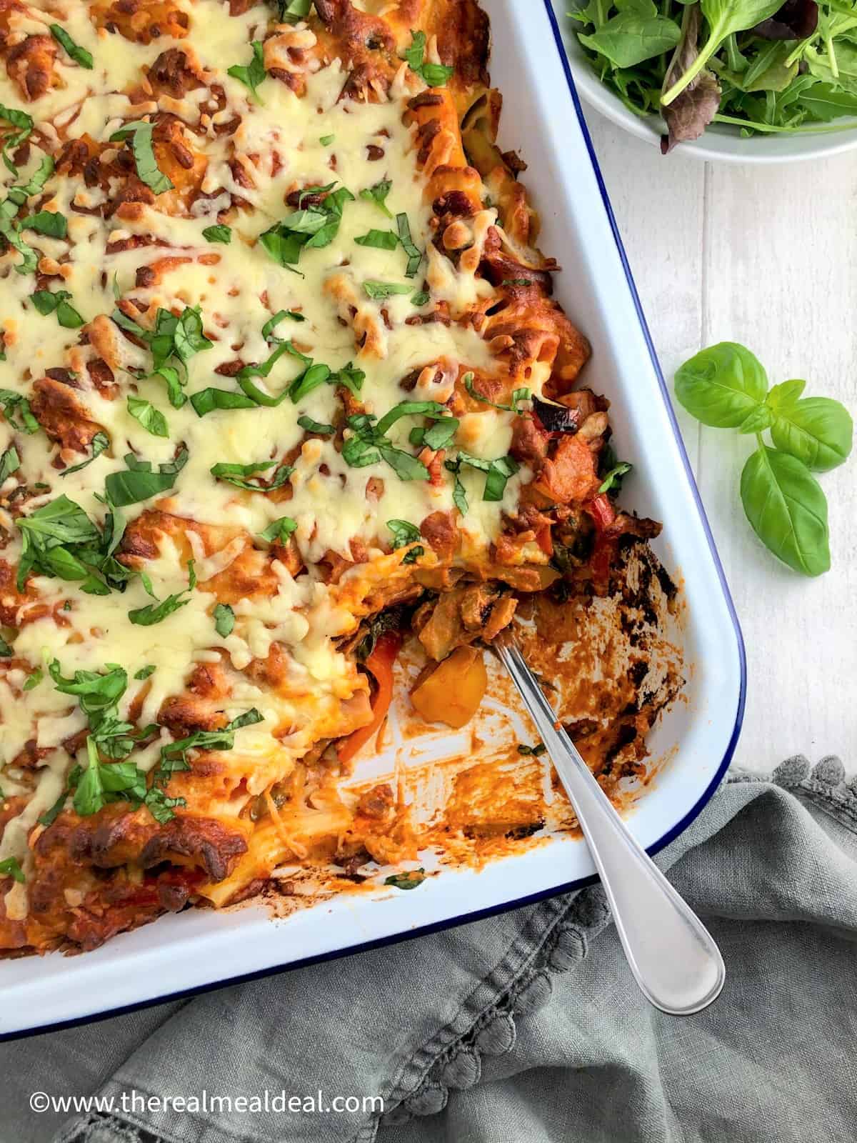 Vegetable Pasta bake in tray topped with fresh basil leaves