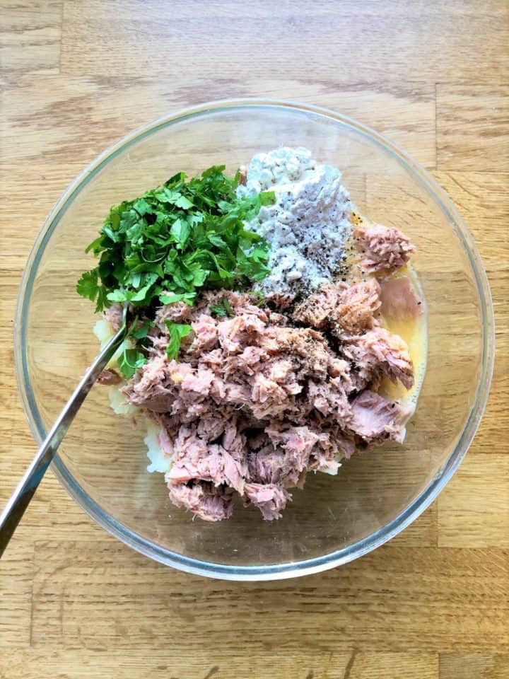 mashed potato flaked tuna egg fresh parsley flour and black pepper in mixing bowl