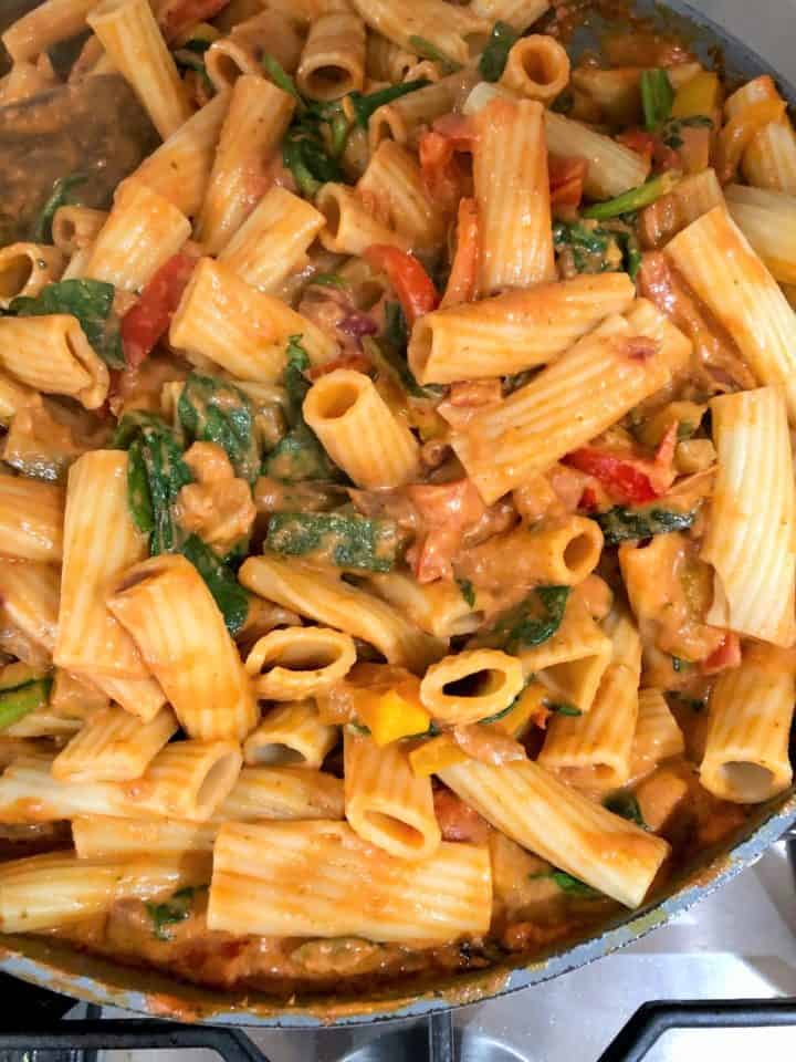pasta stirred into sauce for pasta bake