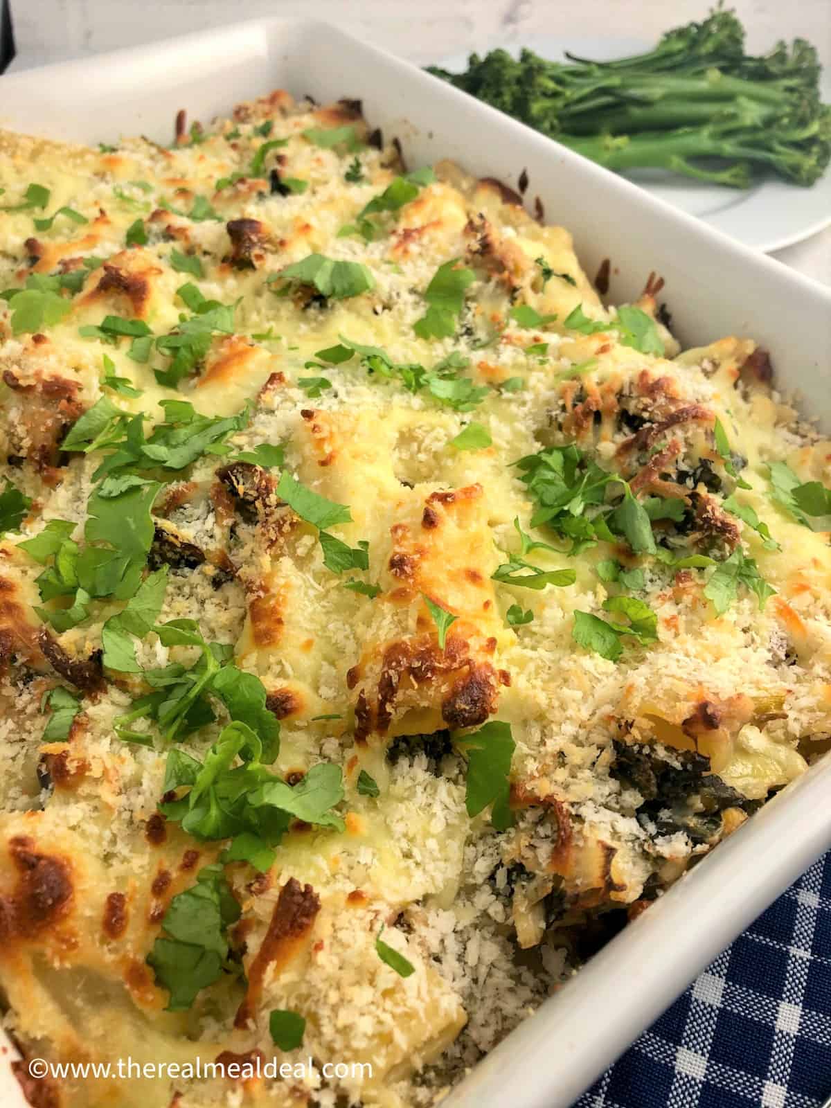 smoked mackerel pasta bake oven baked in tray topped with fresh parsley broccoli in background