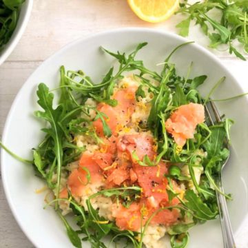smoked salmon risotto topped with rocket leaves and lemon zest