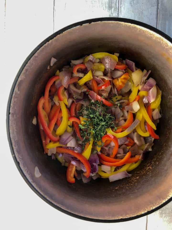 diced red onions peppers and thyme in casserole dish