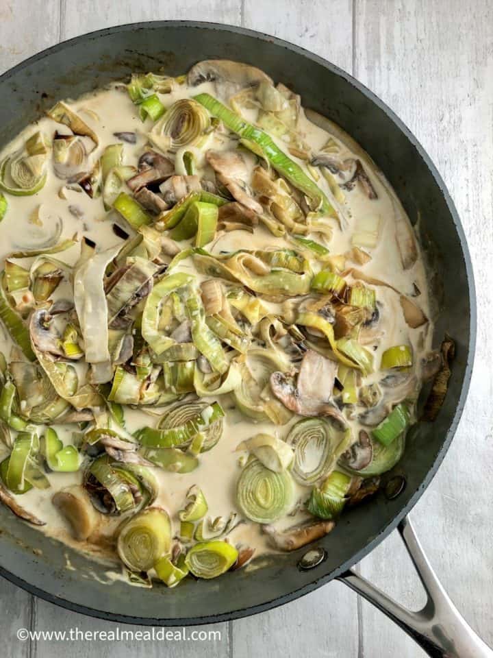 cream added to stock and white wine and stirred into leeks and mushrooms.
