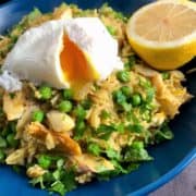 Smoked haddock kedgeree with poached egg in bowl with lemon half and topped with fresh parsley
