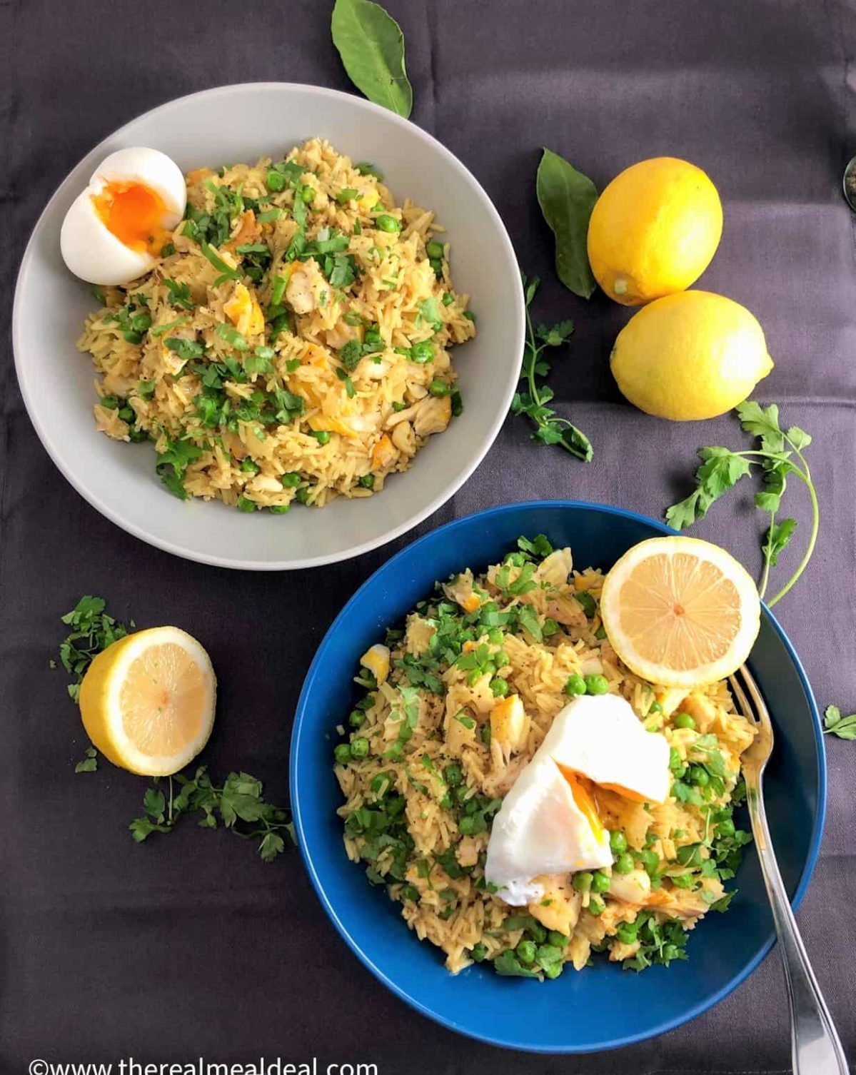 smoked haddock with kedgeree and poached egg in two bowls next to lemons and parsley