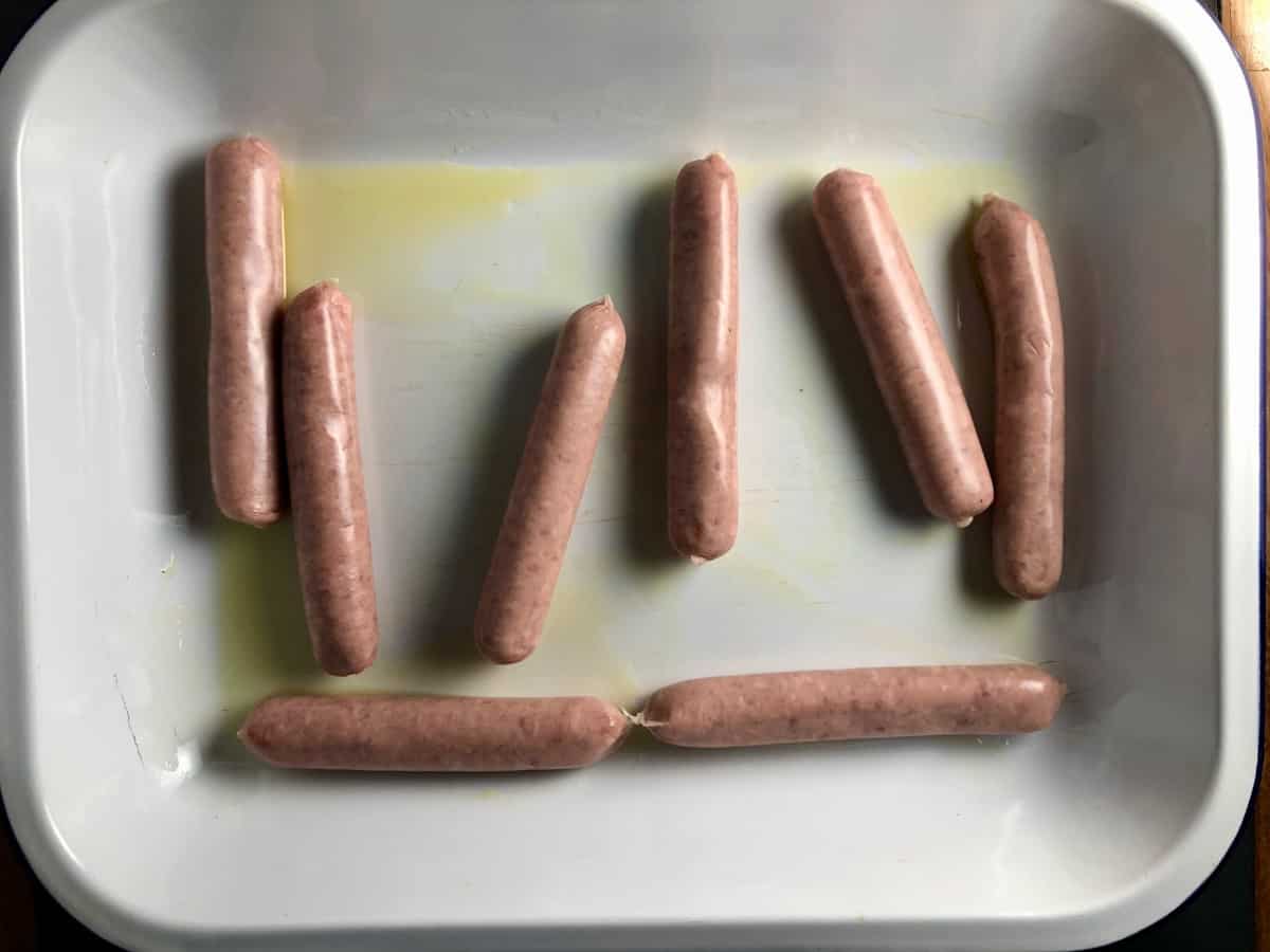 sausages in metal tray with oil