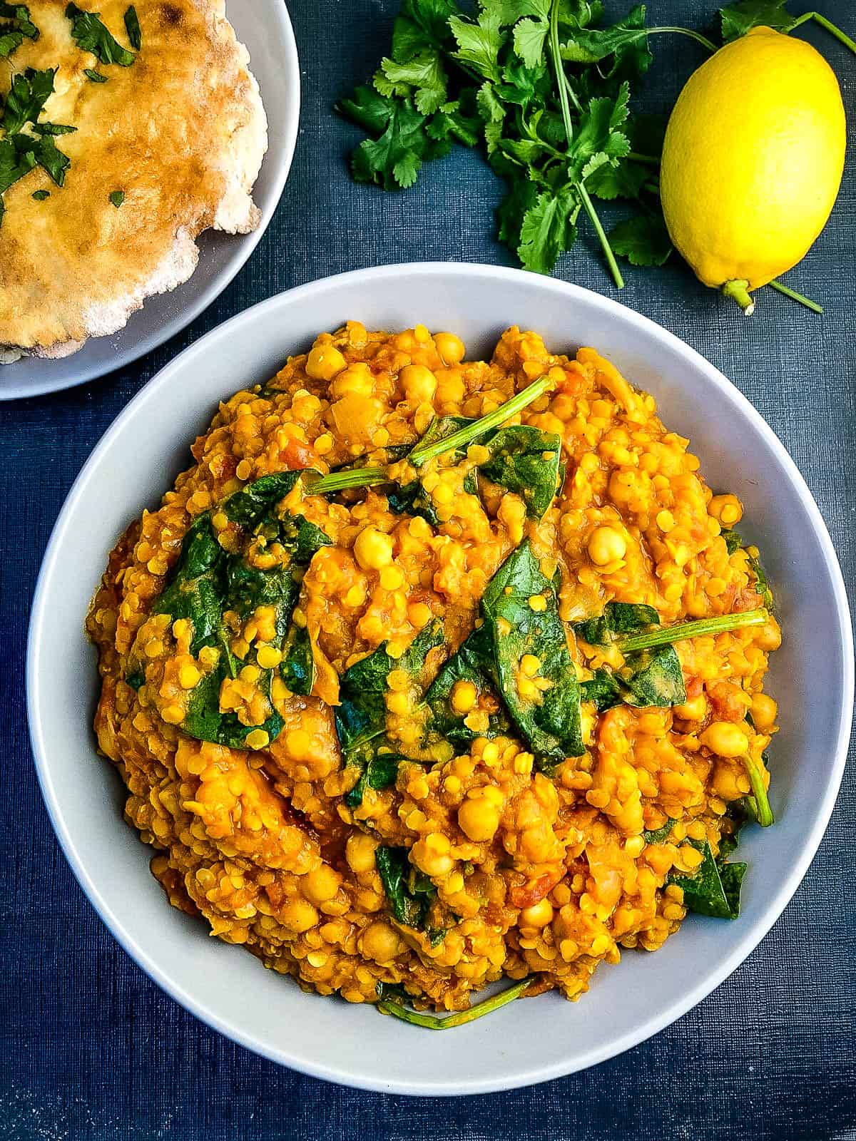 red lentil and chickpea curry with spinach in a bowl.