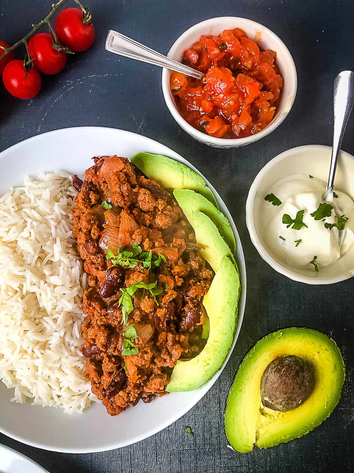 quorn chilli in bowl with rice and sliced avocado soured cream and avocado to side