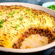 quorn cottage pie in dish with portion removed and side of garden peas