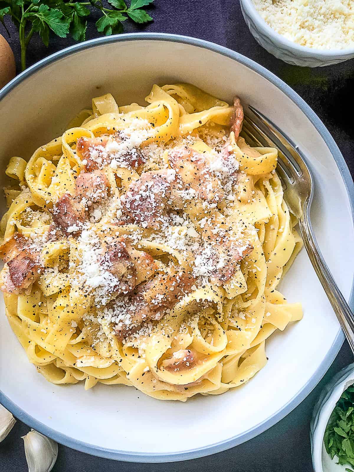 tagliatelle carbonara in bowl topped with parmesan