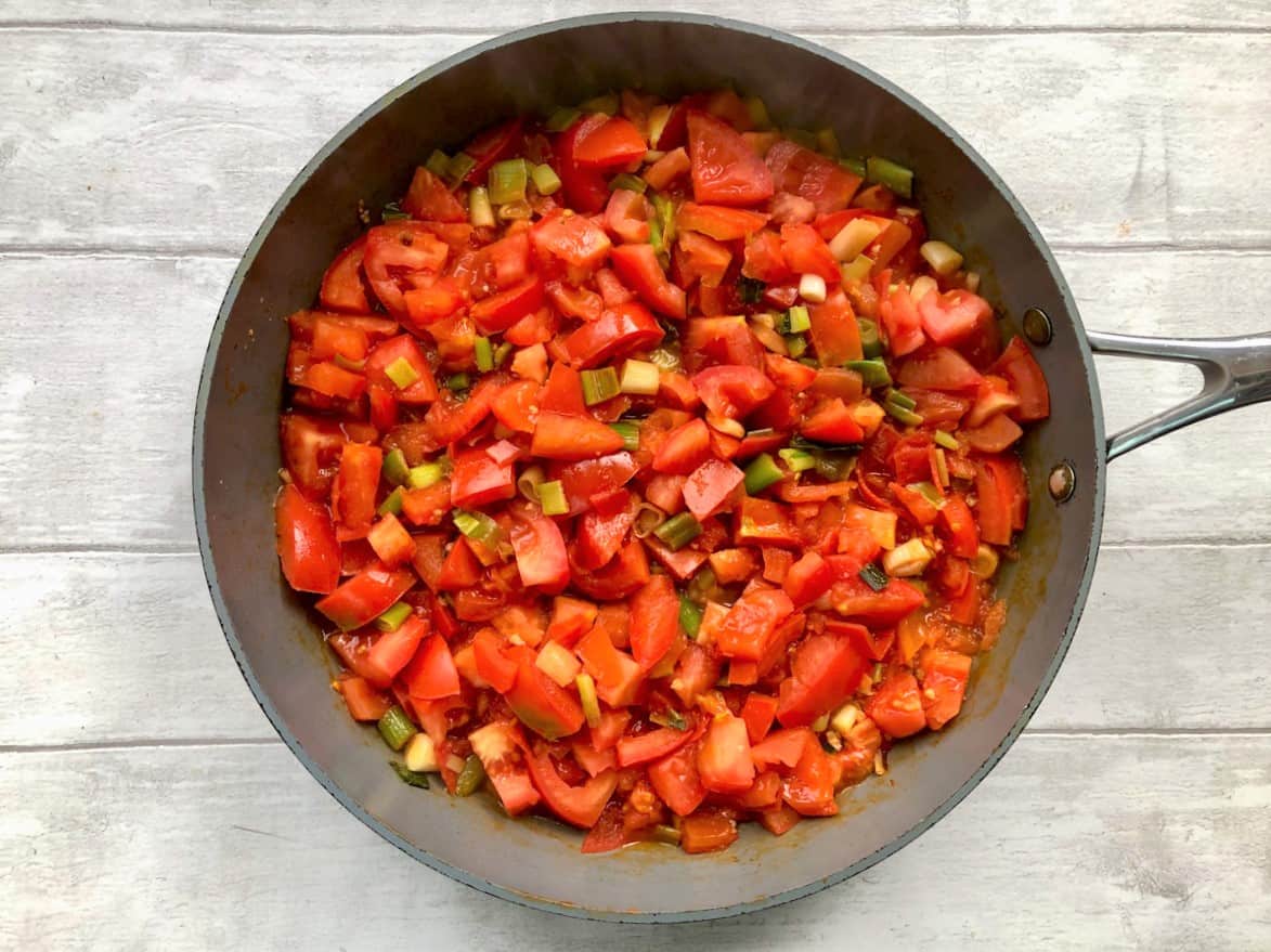 fresh diced tomatoes added to onions in pan