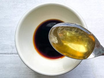 soy sauce in bowl with tablespoon of honey ready to be stirred in