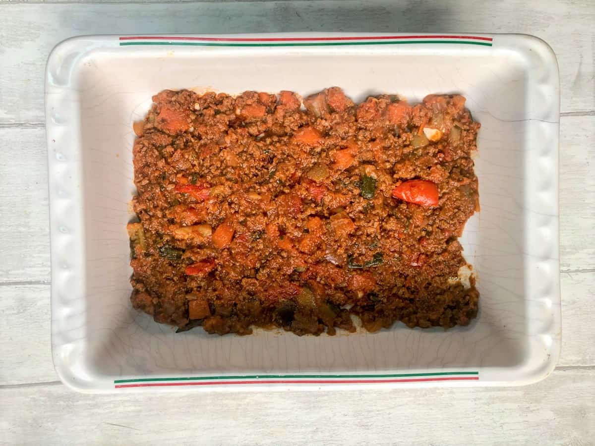 quorn mince bolognese sauce in thin layer over bottom of lasagne dish