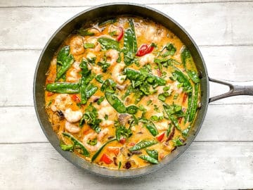 coriander leaves or cilantro added to red prawn curry in pan