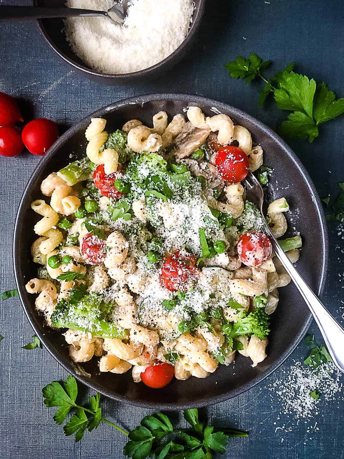 creamy vegetable pasta in bowl topped with parmesan cheese