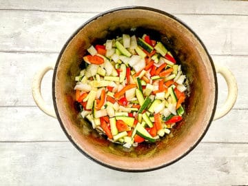courgette or zucchini and red pepper and onion in pan.