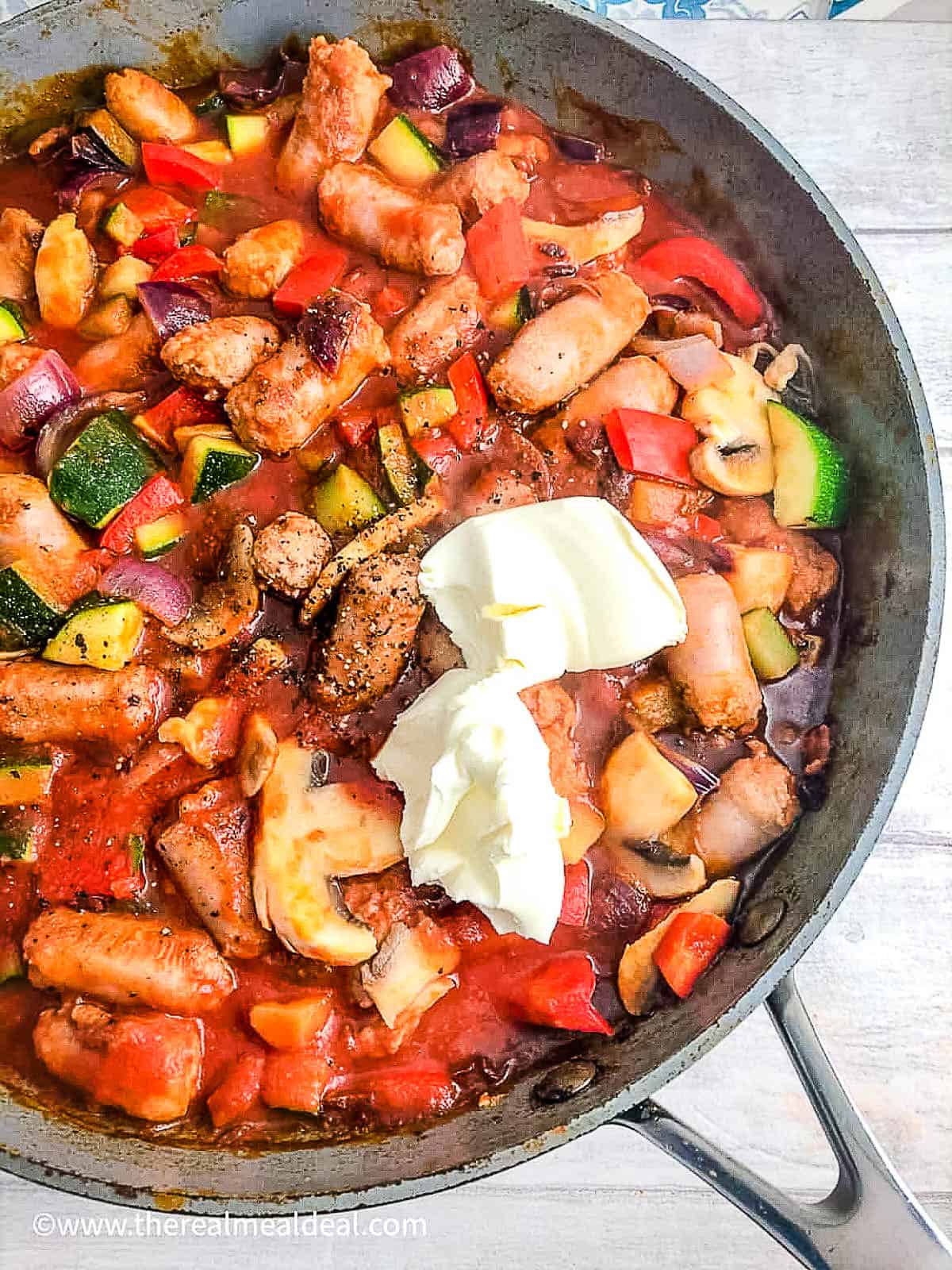 courgette peppers onion mushrooms in pan with sausages, passata and cream cheese.