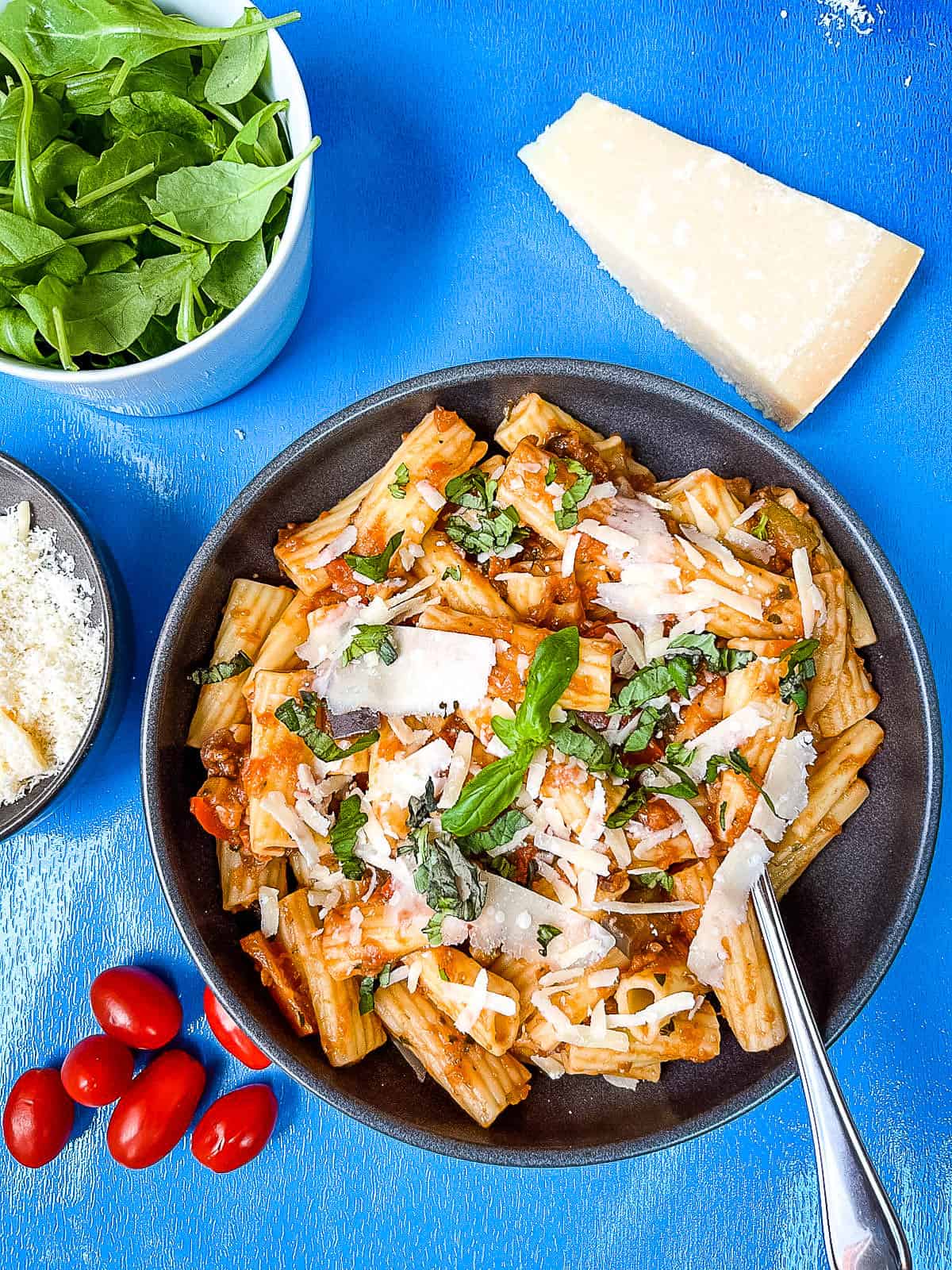 bowl of passata pasta sauce with mediterranean vegetables topped with grated parmesan cheese