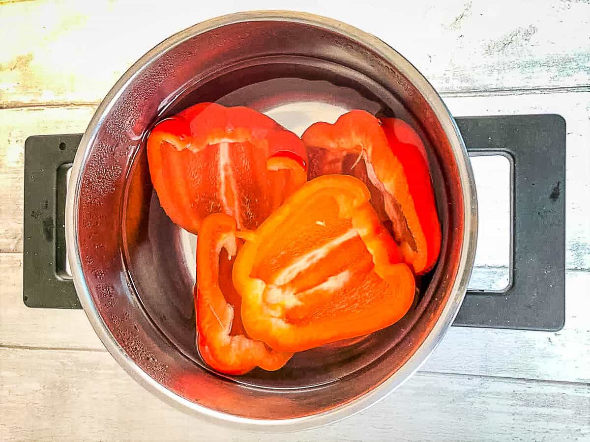 red bell pepper halves in pan of water
