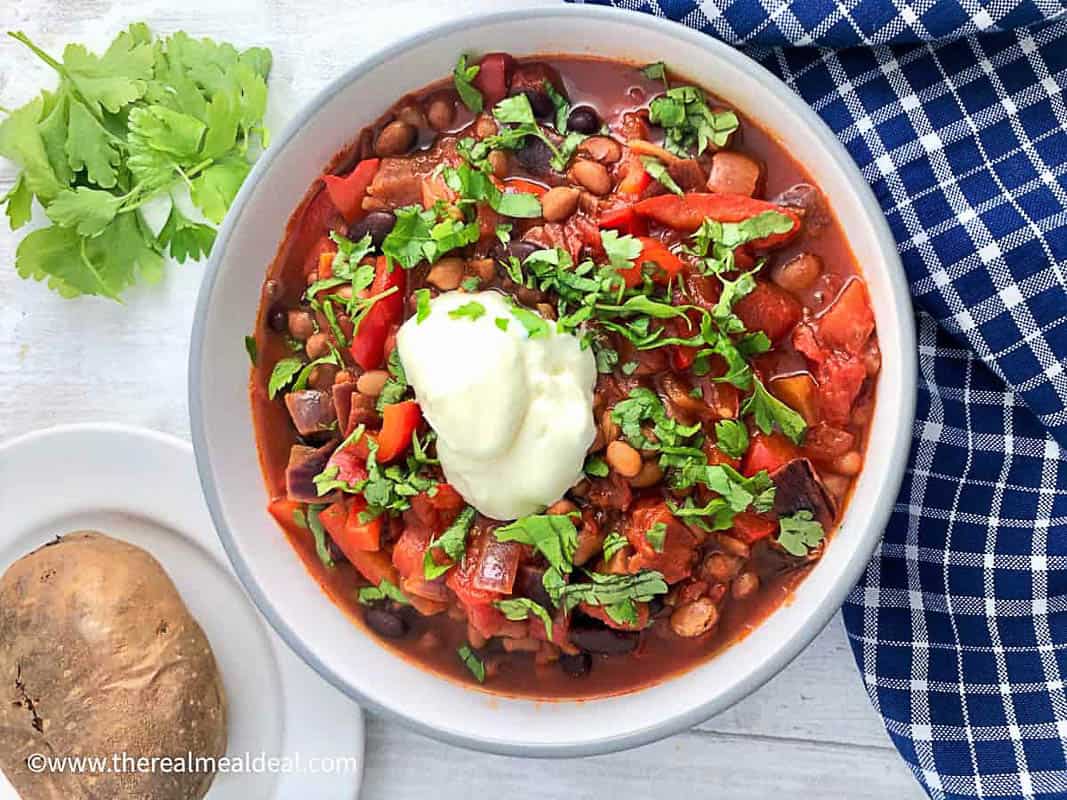 bowl of hungarian vegetarian bean goulash topped with soured cream