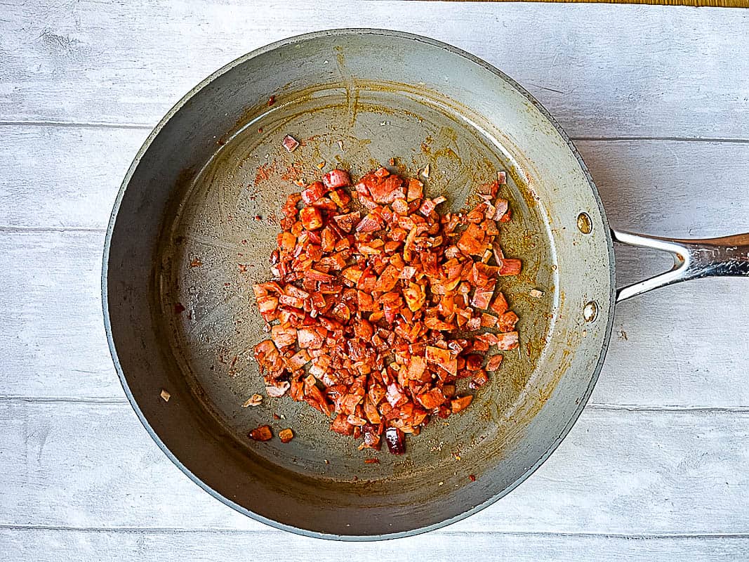 red onion and mild chilli powder in frying pan