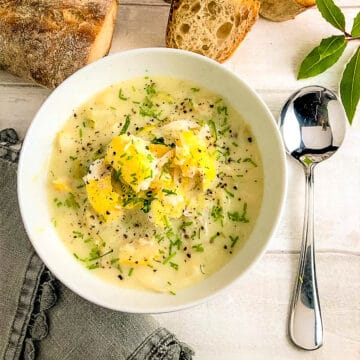 bowl of cullen skink topped with fresh chives, crusty bread to side