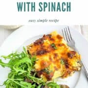 pinterest image for salmon lasagne with spinach showing portion on plate with green salad