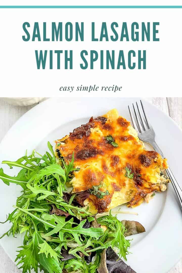pinterest image for salmon lasagne with spinach showing portion on plate with green salad