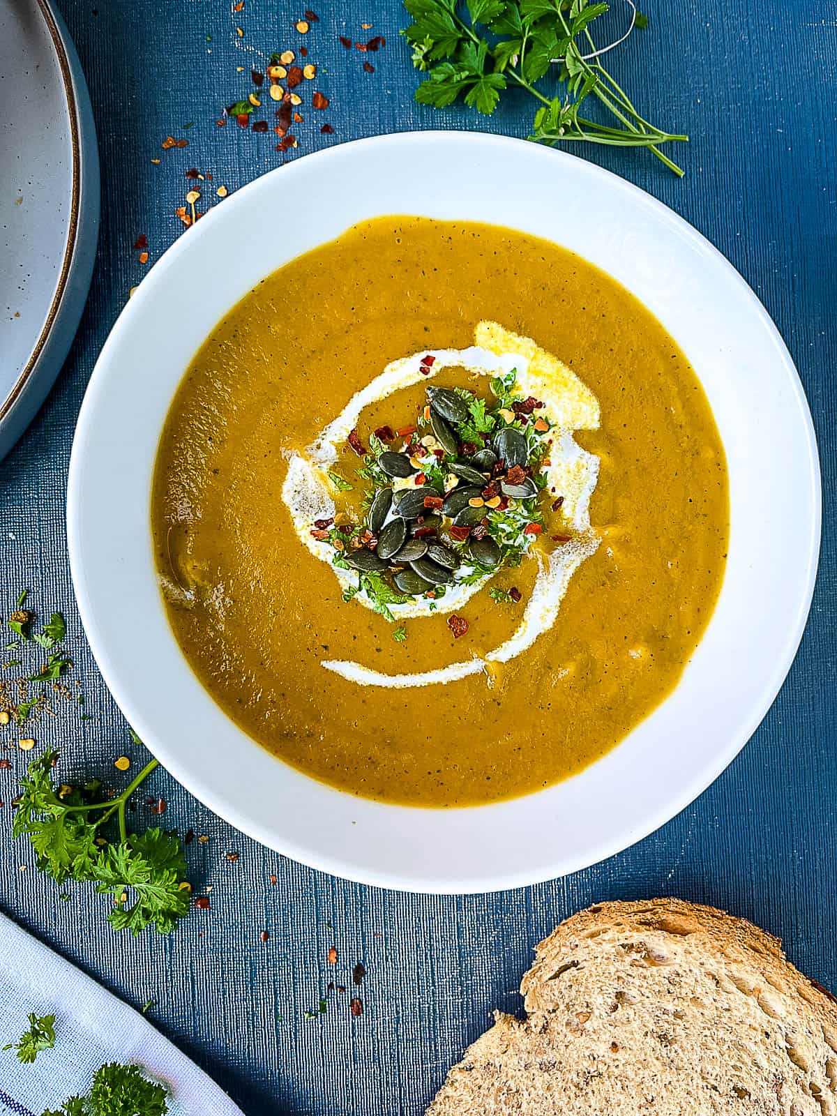 Carrot and Courgette Zucchini Soup served with a swirl of cream and pumpkin seeds