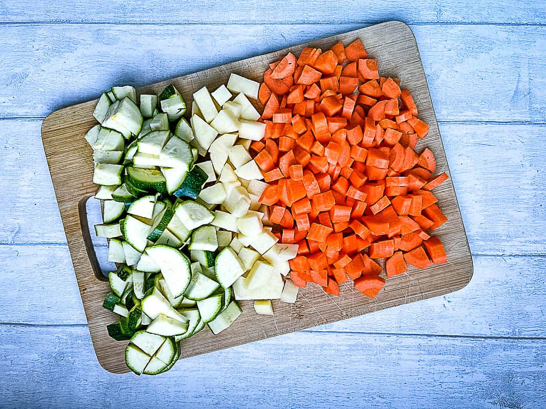 diced courgette or zucchini potato and carrot on chopping board