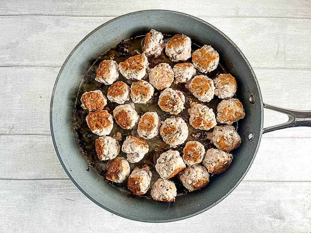 pork meatballs browned in a pan or skillet