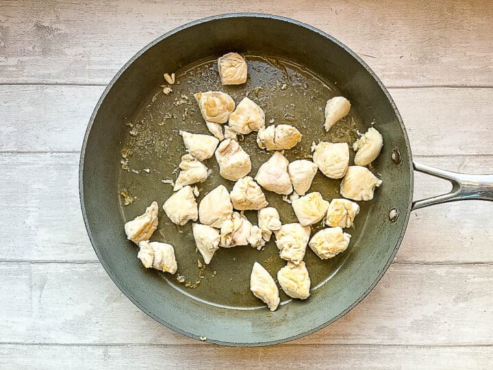 chicken pieces frying in pan