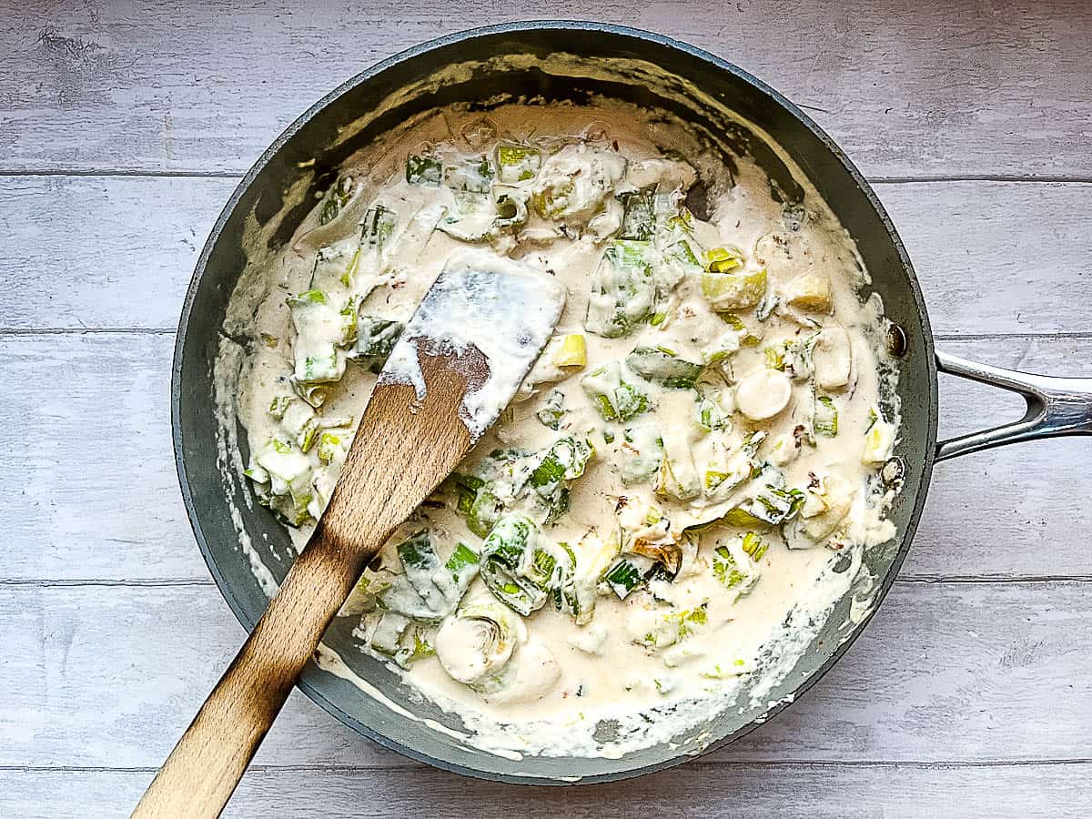 leeks with cream cheese and milk craemy sauce in pan