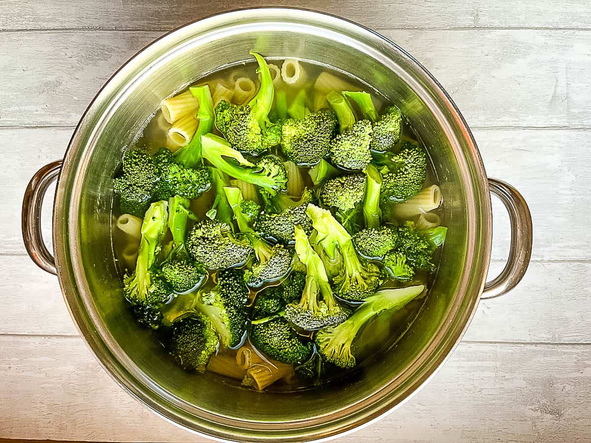 pasta and broccoli simmering in large pan of salted water