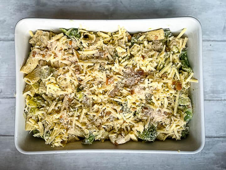 chicken and broccoli pasta bake topped with cheese ready for the oven