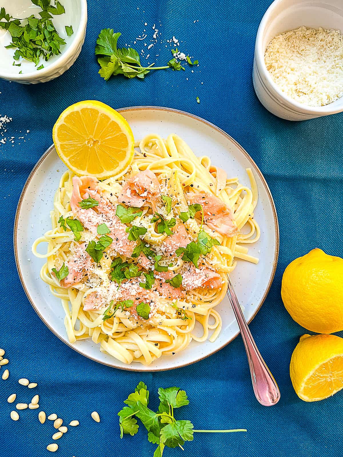 smoked salmon pasta carbonara no cream served on a plate with lemon and parmesan cheese