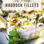 close up of cooked haddock fillets with lemon and chives.
